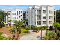 Beautiful white condo building with palm trees and manicured landscaping at 108 Fairbanks Oak Aly # 201, Charleston, SC 29492