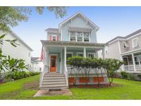 Charming two-story home with a covered porch and orange front door, enhancing its curb appeal at 1348 Seaside Plantation Dr, Charleston, SC 29412