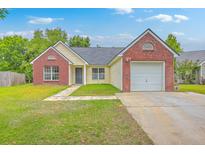 Charming single-Gathering home featuring a brick facade, attached garage, and a well-maintained lawn at 206 Barnwell St, Summerville, SC 29483