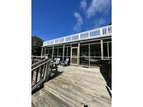 Spacious screened porch with wood floors, comfortable seating, and great views for relaxing and entertaining at 211 Pelican Flight Dr # 1/6Th Share, Dewees Island, SC 29451