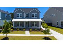 Charming two-story home features a landscaped yard, a welcoming front porch and a light blue front door at 232 Ashworth Dr, Summerville, SC 29486
