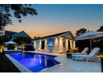 Beautifully lit pool area with lounge chairs and outdoor television for evening entertainment at 2792 River Vista Way, Mount Pleasant, SC 29466