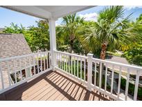 A beautiful balcony with white railings overlooking green palm trees and landscaping at 2947 Sweetleaf Ln, Johns Island, SC 29455