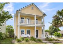 Inviting two-story home with a charming porch swing and a double balcony, perfect for enjoying the outdoors at 2961 Waterleaf Rd, Johns Island, SC 29455