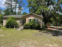 Quaint single-story home with a ramp and lush greenery in the front yard at 311 Hill St, Walterboro, SC 29488