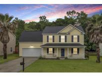 Charming two-story home featuring a welcoming front porch, two-car garage, and beautiful landscaping at 327 Eagle Ridge Rd, Summerville, SC 29485