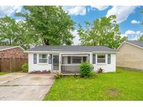 Charming single-story home featuring a well-maintained lawn and a welcoming screened in porch at 40 Elmwood Pl, Goose Creek, SC 29445