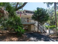 Charming elevated home with a porch, stairs, and an American flag flying out front at 554 Double Eagle Trce, Seabrook Island, SC 29455