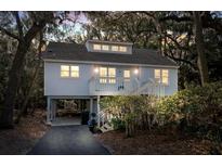 Charming coastal home with a inviting porch, staircase, and an elevated foundation amidst lush foliage at 555 Double Eagle, Seabrook Island, SC 29455