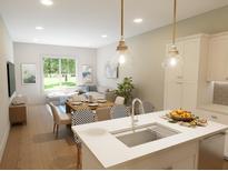 Open concept living area with modern kitchen, dining, and comfortable seating, flooded with natural light from large windows at 7622 Indigo Palms Way, Johns Island, SC 29455
