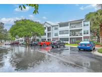 Modern condo building featuring balconies, well-maintained landscaping, and ample parking space for residents and guests at 1025 Riverland Woods Pl # 904, Charleston, SC 29412