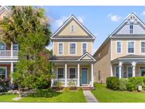 Charming yellow two-story home with a cozy front porch and manicured lawn, exuding curb appeal at 104 Hyacinth St, Summerville, SC 29483