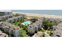 Beautiful aerial view of the property, community pool, and pristine beach at 9000 Palmetto Dr # C104, Isle of Palms, SC 29451