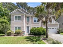 Charming two-story home featuring a well-manicured lawn, two-car garage, and mature landscaping at 113 Southernwood Dr, Ladson, SC 29456