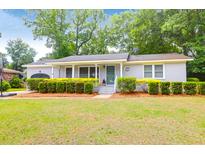 Charming one-story home featuring a well-manicured lawn and beautiful front yard landscaping at 1416 Glencoe Dr, Mount Pleasant, SC 29464