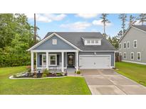 Charming blue home featuring a well-manicured lawn and a cozy front porch with rocking chairs at 148 Haverhill St, Summerville, SC 29486