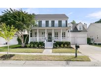 Inviting two-story home featuring a charming front porch, black shutters, and well-maintained landscaping at 1517 Faith St, Mount Pleasant, SC 29466