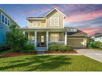 Charming two-story home featuring a welcoming front porch, well-manicured lawn, and attached garage, perfect for a Gathering at 1545 Calaveras Cir, Mount Pleasant, SC 29466