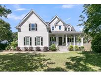 Charming two-story home featuring a spacious porch, manicured lawn, and classic architectural details at 1761 Old Military Rd, Charleston, SC 29412