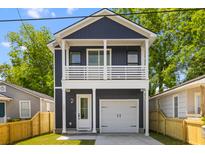 Charming two-story home featuring a spacious garage, a delightful balcony, and a beautifully landscaped front yard at 1989 Groveland Ave, North Charleston, SC 29405