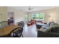 Bright living room features a comfortable gray sectional couch, leather chair, and a view of the outdoors at 2011 N Highway 17 # 1400P, Mount Pleasant, SC 29466