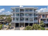 Multi-story condo building with balconies and covered parking spaces below at 216 W Arctic Ave # 9, Folly Beach, SC 29439