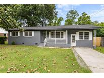 Charming gray brick ranch-style home with well-maintained front yard, walkway and covered porch at 323 Amy Dr, Goose Creek, SC 29445