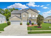 Charming two-story home with a well-maintained lawn, two car garage, and manicured landscaping at 334 Cicadas Song Dr, Moncks Corner, SC 29461