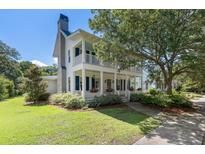 Charming two-story home features a double porch, manicured landscaping, and lovely curb appeal at 3426 Acorn Drop Ln, Johns Island, SC 29455
