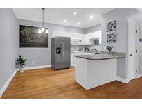 Bright kitchen featuring white cabinets, stainless steel appliances, granite countertops, and hardwood floors at 4003 Radcliffe Place Dr # B6, Charleston, SC 29414
