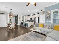Open-concept living room featuring a modern design, sleek furniture, and a seamless connection to the kitchen and dining area at 4235 Scharite St, Charleston, SC 29414