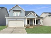 Charming two-story home with light blue siding, a white garage door, and a well-manicured lawn at 459 White Magnolia St, Moncks Corner, SC 29461