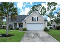 Charming single-Gathering home with a well-manicured lawn, two car garage, and lush landscaping at 465 Blue Dragonfly Dr, Charleston, SC 29414