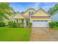 Charming yellow home with a well-maintained lawn and attached two-car garage at 493 Nelliefield Trl, Wando, SC 29492