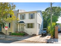 Charming two-story white home with green shutters, a well-manicured yard, and a convenient parking area at 5 Smith St, Charleston, SC 29401
