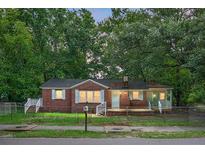 Charming single-story brick home with light blue shutters nestled among mature trees at 5056 Piedmont Ave, North Charleston, SC 29406