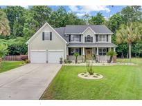 Charming two-story home with a well-manicured lawn, a two-car garage, and inviting front porch at 9524 Markley Blvd, Summerville, SC 29485