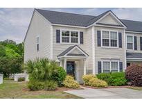 Charming townhome featuring neat landscaping, dark shutters, and a welcoming front entrance at 1003 Washitonia Way # A, Charleston, SC 29492