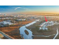 Stunning aerial view of waterfront community with marsh views at sunrise, showcasing coastal living and charming homes at 1022 Hunley Waters Cir, North Charleston, SC 29405