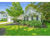 Charming home with mature landscaping and a well-maintained front yard on a sunny day at 104 S Ansel Xing, Goose Creek, SC 29445