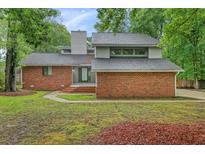 A two-story brick home has modern architectural details and mature landscaping at 105 Londonderry Rd, Goose Creek, SC 29445