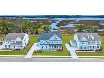 Stunning aerial view of the light blue two-story home with a water view at 1095 Saltwater Cir, Johns Island, SC 29455