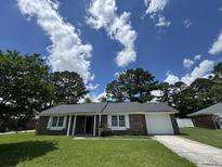 Charming brick home featuring a well-manicured lawn, attached garage, and inviting front entrance at 1102 Hampton Ct, Summerville, SC 29486