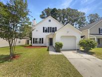 Charming two-story home featuring an attached garage and a well-maintained lawn and landscape at 1128 Peninsula Cove Dr, Charleston, SC 29492