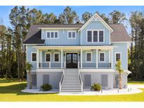 Charming two-story home with a inviting front porch and a well-manicured lawn and a beautiful garden at 1327 Wood Sorrel Dr, Moncks Corner, SC 29461