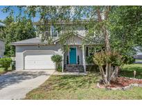 Charming two-story home with a light gray exterior, a blue front door, and well-maintained landscaping at 137 Ashton Dr, Goose Creek, SC 29445