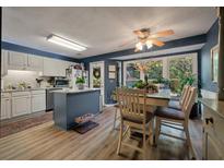 Bright kitchen features white cabinets, stainless appliances, central island, and adjacent dining area with views to the backyard at 1414 E Crossing Ln, Mount Pleasant, SC 29466