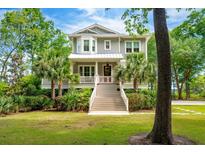 Charming two-story home with a porch, landscaped yard, and palm trees at 1510 Old Rosebud Trl, Awendaw, SC 29429