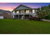 Inviting two-story home with a charming front porch, lush green lawn and mature landscaping in a peaceful neighborhood at 1512 Eagle Landing Blvd, Hanahan, SC 29410