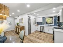 Bright kitchen features stainless steel appliances, white cabinetry, and stylish blue tile backsplash at 153 High Hammock Villas, Seabrook Island, SC 29455